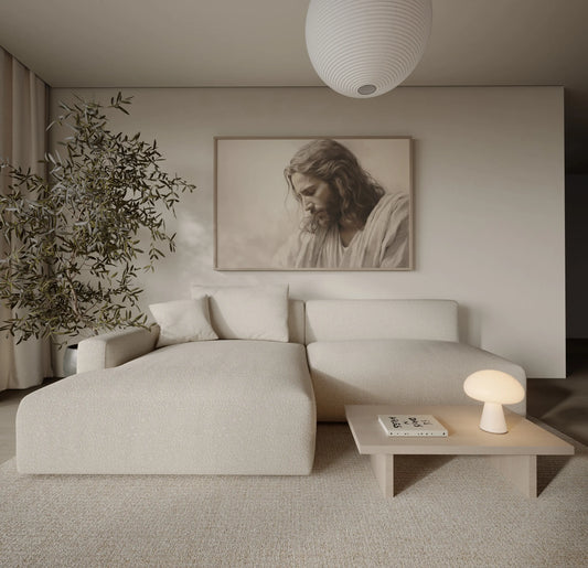 Sepia-toned Jesus portrait print in a Scandinavian neutral living room with olive tree and white couch