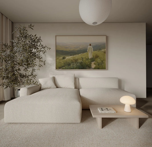 Jesus walking toward a bright golden horizon through a wildflower field art print above a sofa in a warm contemporary living room – JesusArtworks
