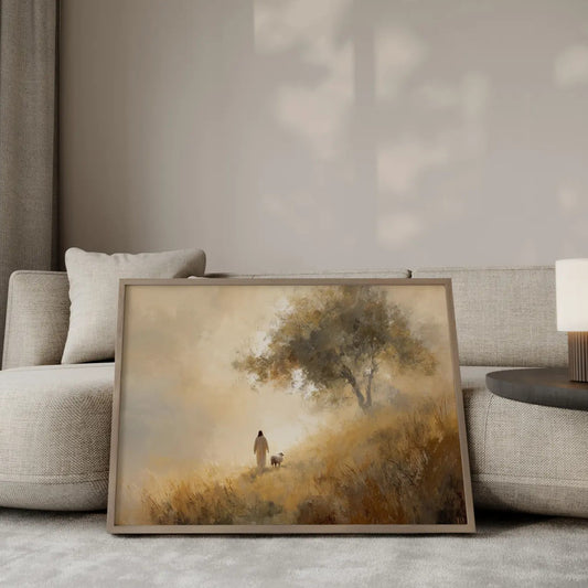 Beside Still Waters Jesus and lamb wall art print in a gold frame leaning against a modern beige sofa – Christian home decor by JesusArtworks
