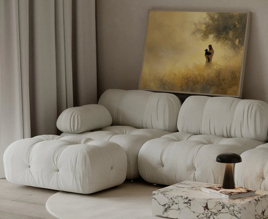 Framed minimalist painting of Jesus holding a black lamb in a golden haze beneath a tree displayed in a neutral living room
