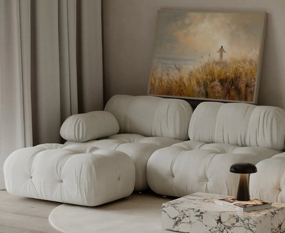 Jesus blessing painting in a golden wheat field overlooking the sea, framed and leaning beside a cream couch in a modern home