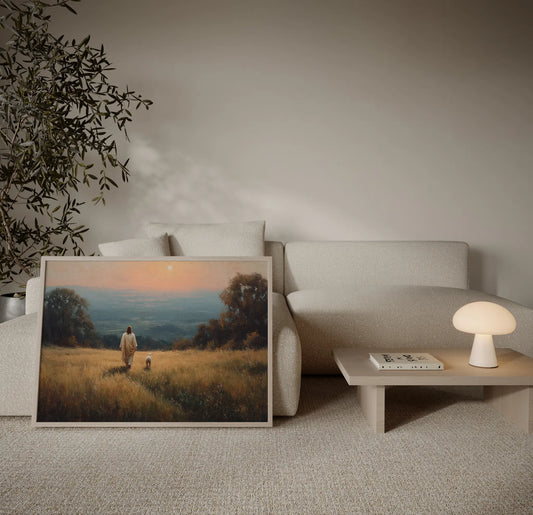 Jesus walking with a lamb in a golden field at sunset Christian art print displayed above a sofa in a warm neutral living room – JesusArtworks