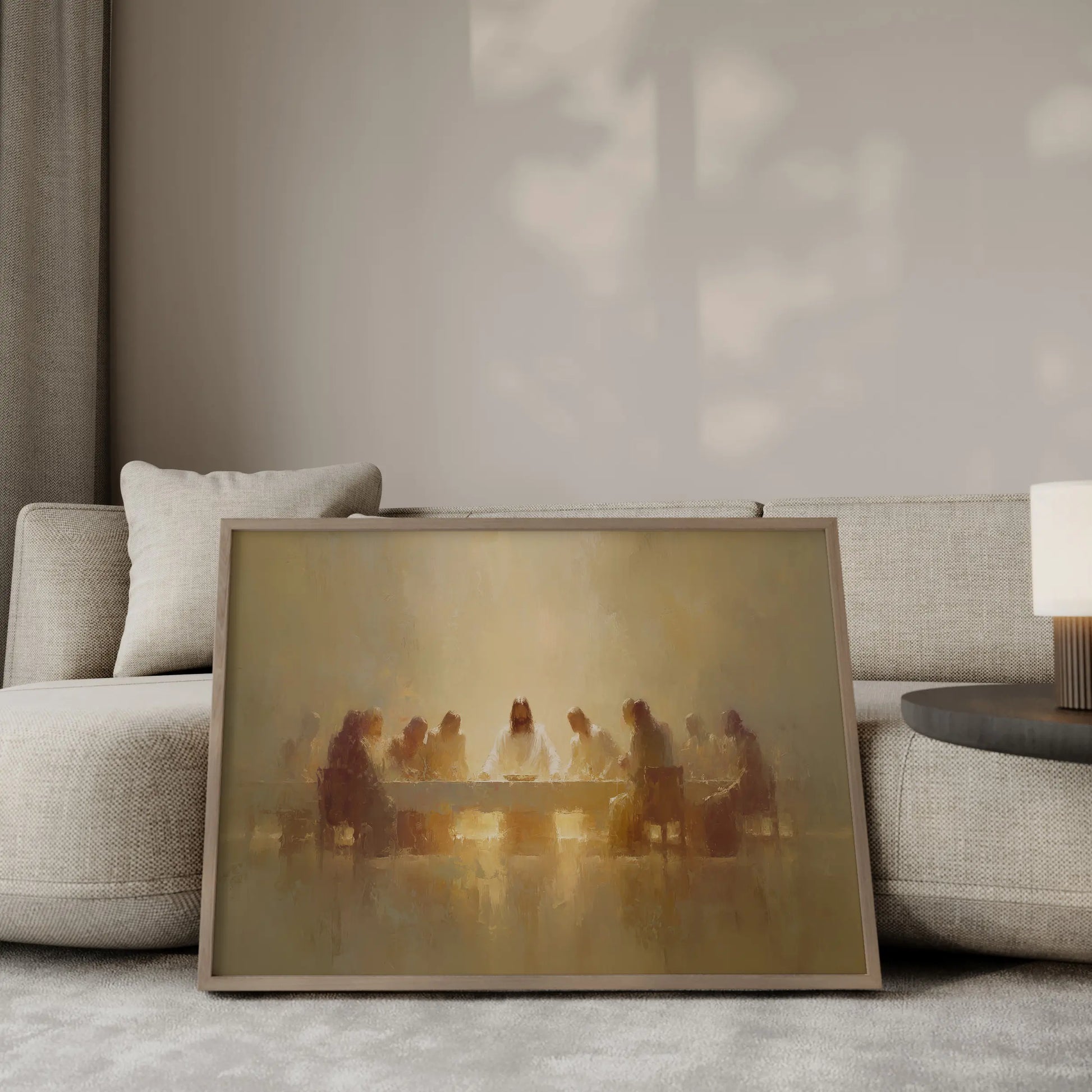 The Sacred Gathering Last Supper wall art print in a gold frame leaning against a modern beige sofa – Christian home decor by JesusArtworks