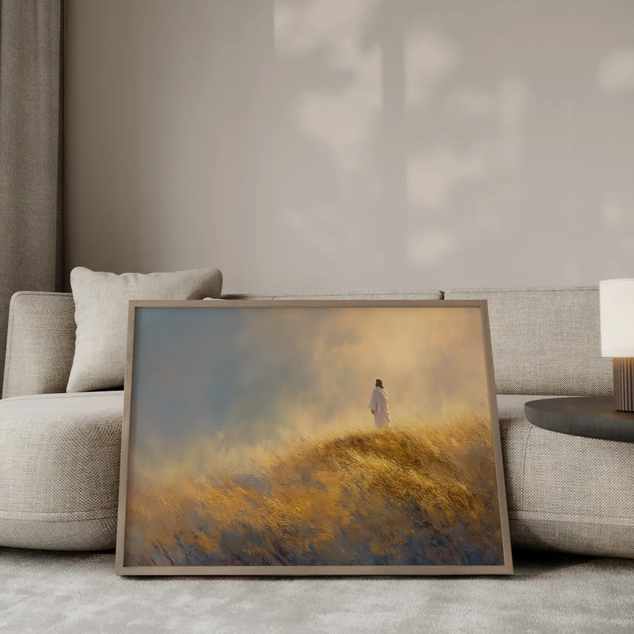 The Narrow Path Jesus walking on a hillside wall art print in a gold frame leaning against a modern beige sofa – Christian home decor by JesusArtworks